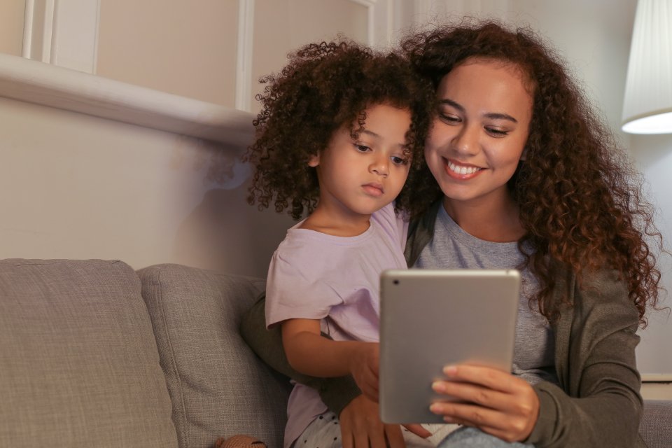 Parent and child using a tablet together at home